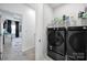 Well-organized laundry room with front-load washer and dryer and shelving for storage and easy access at 2656 Grantham Place Dr, Fort Mill, SC 29715