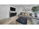 Living room featuring sleek black cabinet, large TV, modern artwork, and gray sofa with stylish pillows at 2656 Grantham Place Dr, Fort Mill, SC 29715