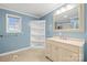 Bathroom with blue walls, tile floor, vanity, mirror, and view into the shower area at 2687 Glenn St, Newton, NC 28658