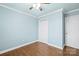 This bedroom has light blue walls, a window, ceiling fan, and modern wood floors at 2687 Glenn St, Newton, NC 28658