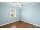 This bedroom has wood floors, a window, ceiling fan, and is painted in light blue at 2687 Glenn St, Newton, NC 28658