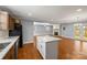 Open living room concept including kitchen island, brick fireplace, and gorgeous hard wood floors at 2687 Glenn St, Newton, NC 28658