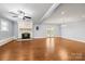 Open living room featuring a ceiling fan, brick fireplace, hardwood floors, and French doors to the exterior at 2687 Glenn St, Newton, NC 28658