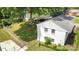 An aerial view of the house showcases the fenced yard, carport, outbuilding, and mature trees at 3231 Eastwood Dr, Charlotte, NC 28205