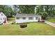 Aerial view showcasing the house with a well-maintained lawn, landscaping, and proximity to mature trees at 3231 Eastwood Dr, Charlotte, NC 28205