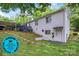 A spacious backyard with lush greenery, a deck, and a white brick house exterior at 3231 Eastwood Dr, Charlotte, NC 28205