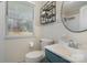 Bathroom featuring modern fixtures, white tile, storage shelves and a window at 3231 Eastwood Dr, Charlotte, NC 28205