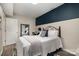 Cozy bedroom featuring a decorative accent wall, a comfortable bed with stylish bedding and a well-lit interior at 3231 Eastwood Dr, Charlotte, NC 28205