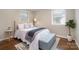 Bright bedroom with a tufted bench at the foot of the bed, and lots of light from the windows at 3231 Eastwood Dr, Charlotte, NC 28205