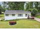 Beautiful single-story home featuring a well-manicured lawn with lush landscaping and vibrant flower beds at 3231 Eastwood Dr, Charlotte, NC 28205