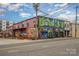 Eye-catching mural-covered building featuring Salud, complete with outdoor picnic table seating at 3231 Eastwood Dr, Charlotte, NC 28205