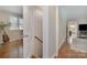 Hallway with wood floors leading to living areas and stairs to the basement at 3231 Eastwood Dr, Charlotte, NC 28205