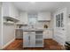 Charming kitchen with white cabinets, movable island and stainless steel appliances at 3231 Eastwood Dr, Charlotte, NC 28205