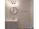 Bathroom featuring a gray vanity, a circular mirror, and gray wood-look flooring at 3410 Nc 109 N Hwy, Wadesboro, NC 28170