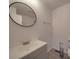 Bathroom featuring a gray vanity, a circular mirror, and gray wood-look flooring at 3410 Nc 109 N Hwy, Wadesboro, NC 28170
