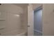Bathroom showcasing a tub and shower with white tiled surround and gray wood-look flooring at 3410 Nc 109 N Hwy, Wadesboro, NC 28170