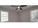 This bedroom has gray walls, a ceiling fan, and natural light from two windows at 3410 Nc 109 N Hwy, Wadesboro, NC 28170