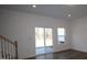 Open-concept living room with wood floors, sliding glass doors to the backyard and staircase at 3427 Secrest Lndg, Monroe, NC 28110