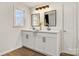 Bright bathroom featuring double sinks, a vanity with granite countertop, new fixtures, and overhead lighting at 3598 Puett Park Dr, Conover, NC 28613