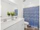 Bright bathroom boasts a double sink vanity and a shower with a stylish blue patterned curtain at 4021 Eckels Dr, Charlotte, NC 28215