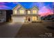Charming two-story home with an attached two-car garage and well-manicured lawn at dusk at 4021 Eckels Dr, Charlotte, NC 28215