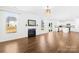 Bright living room with fireplace, wood floors, and view to kitchen at 4021 Eckels Dr, Charlotte, NC 28215