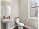 Powder room featuring a pedestal sink, round mirror, and natural light at 4028 Shadowbrook Rd, Waxhaw, NC 28173