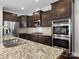 Modern kitchen featuring granite countertop, stainless steel appliances, and dark wood cabinets at 4028 Shadowbrook Rd, Waxhaw, NC 28173