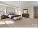 Spacious main bedroom featuring a tray ceiling, large bed, and natural light at 4028 Shadowbrook Rd, Waxhaw, NC 28173