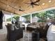 Inviting covered patio featuring comfortable seating, ceiling fans, and an outdoor area with mature trees at 4028 Shadowbrook Rd, Waxhaw, NC 28173