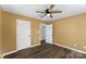 This bedroom features warm-toned walls, a ceiling fan, two closets, and sleek, wood-look flooring at 406 E 29Th St, Kannapolis, NC 28083