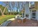 Brick patio with a built in outdoor kitchen, fireplace and a dining table at 4117 Tyng Way, Charlotte, NC 28211