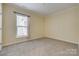 Bright bedroom featuring a window, light-colored walls, neutral carpet, and modern trim at 4521 Middlebury Ln, Fort Mill, SC 29715