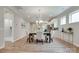 An open concept dining area with hardwood floors, a modern chandelier and dining set, and natural light streaming through windows at 4521 Middlebury Ln, Fort Mill, SC 29715