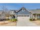 Charming home with a two-car garage, blue siding, manicured landscaping and a clear blue sky at 4521 Middlebury Ln, Fort Mill, SC 29715