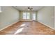 Spacious living room with hardwood floors, fan, and a glass door leading outside at 4521 Middlebury Ln, Fort Mill, SC 29715