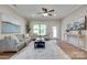 An inviting living room featuring hardwood floors, natural light, neutral toned decor, and contemporary furnishings at 4521 Middlebury Ln, Fort Mill, SC 29715