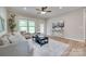 Comfortable living room featuring hardwood floors, a modern ceiling fan, natural light, and stylish contemporary furnishings at 4521 Middlebury Ln, Fort Mill, SC 29715