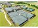 An aerial view captures multiple tennis courts surrounded by lush landscaping and mature trees in a vibrant community at 4521 Middlebury Ln, Fort Mill, SC 29715