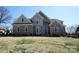 Charming brick home featuring a symmetrical design, arched windows, and well-manicured lawn under a clear blue sky at 4531 Landmark Dr, Rock Hill, SC 29732