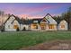 Stunning home featuring a white brick facade, black roof, and manicured front lawn at sunset at 515 Deanne Dr, Rock Hill, SC 29730