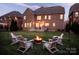 Inviting backyard features a cozy fire pit surrounded by chairs, string lights, and a spacious lawn at 5430 Open Book Ln, Charlotte, NC 28270
