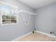 Neutral laundry room with tile flooring, white wire shelving, and a view from a bright window at 624 Harris Nw St, Concord, NC 28025