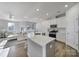 Modern kitchen with quartz countertops, stainless steel appliances, and island seating flowing into living area at 7006 Everly Commons Ln, Fort Mill, SC 29708