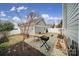 Backyard featuring stone paver patio, landscaping, grill, and outdoor dining table at 786 Stratford Run Dr, Fort Mill, SC 29708
