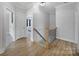 Bright upstairs hallway featuring hardwood floors, neutral paint, and a view into the primary bedroom at 786 Stratford Run Dr, Fort Mill, SC 29708