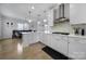 Gourmet kitchen with white cabinetry, stainless steel appliances, modern range hood, and an open view into the dining area at 786 Stratford Run Dr, Fort Mill, SC 29708