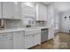 Well-lit kitchen featuring white cabinetry, a farmhouse sink, stainless steel appliances, and mosaic tile backsplash at 786 Stratford Run Dr, Fort Mill, SC 29708