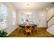 Well-lit dining area featuring hardwood floors, large windows, and a modern light fixture, perfect for Gathering meals at 8157 Merryvale Ln, Charlotte, NC 28214