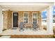 Charming front porch featuring a seating area, complemented by stone accents and a welcoming entrance at 8157 Merryvale Ln, Charlotte, NC 28214